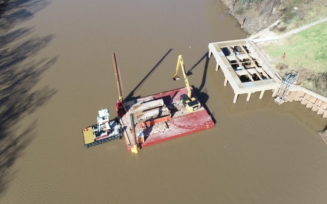 EXCAVATOR PLACES RIPRAP IN BRAZOS